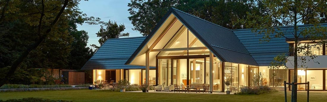 moderne glazen villa overdag met zicht op domotica integratie.