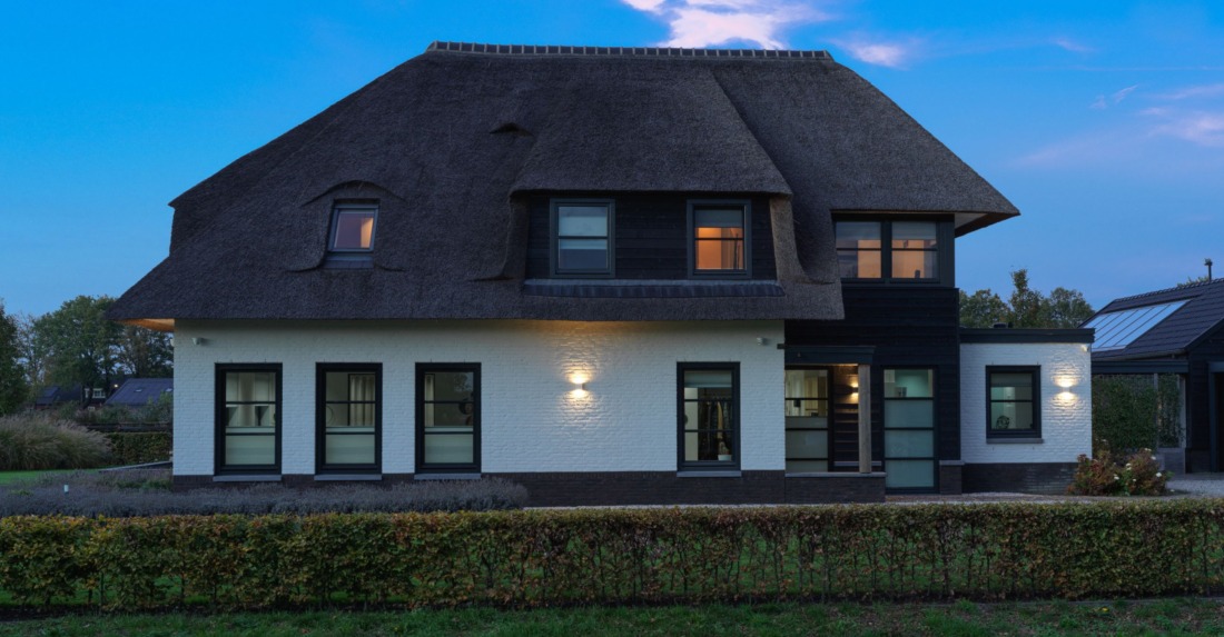 rietgedekte witte villa met dynamische verlichting door domotiqa
