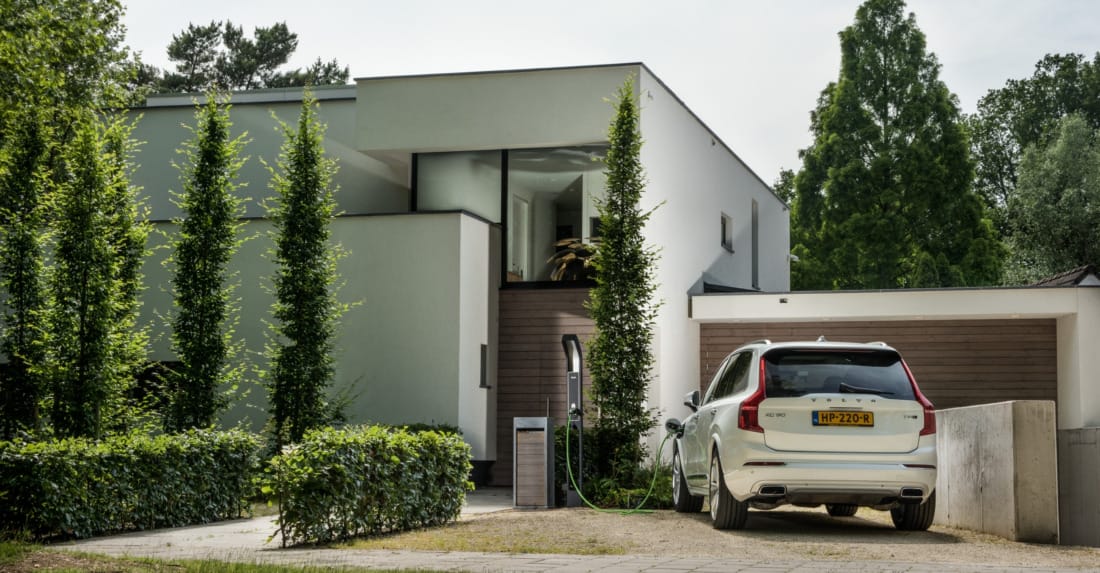 witte moderne villa met beveiligingscamera en buitenverlichting.