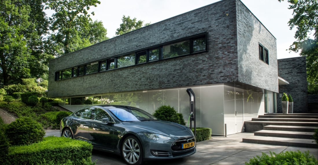 strakke grijze woning met zonwering en domotica sturing.