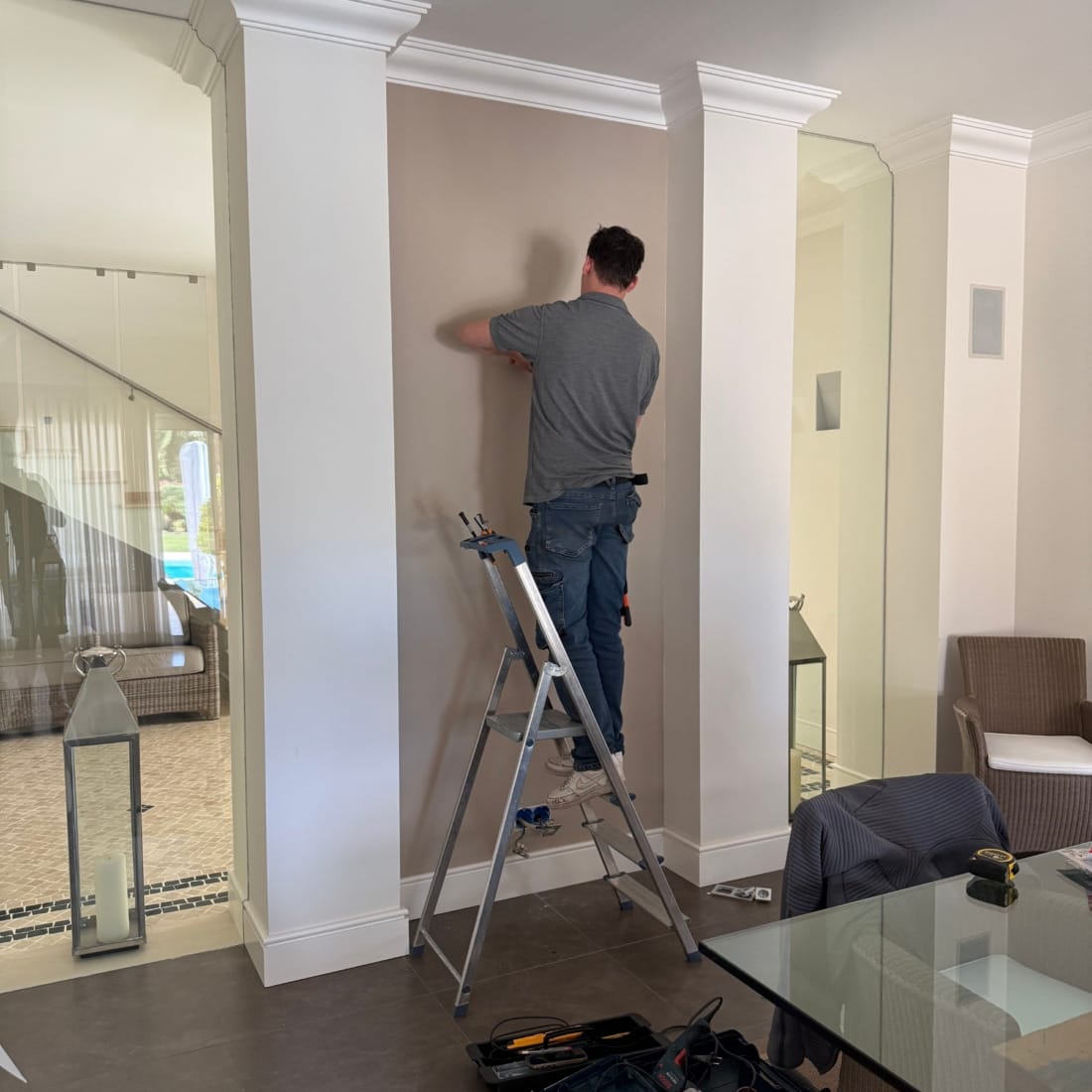 installateur op ladder voor montage van plafondverlichting.