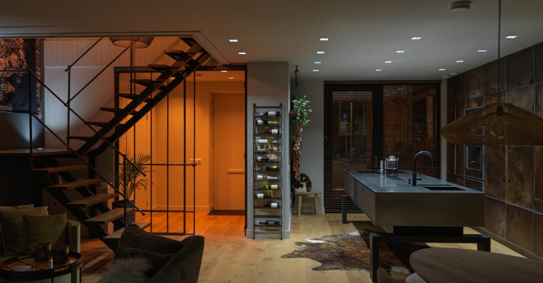 luxe verlichting onder trap met glazen deuren en accentverlichting.