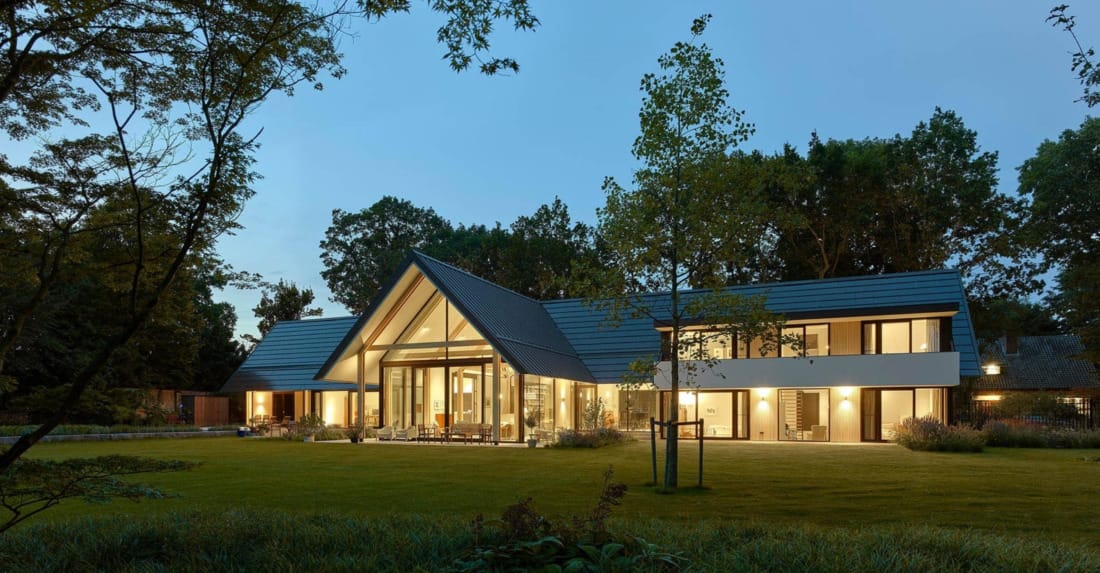 moderne glazen villa overdag met zicht op domotica integratie.