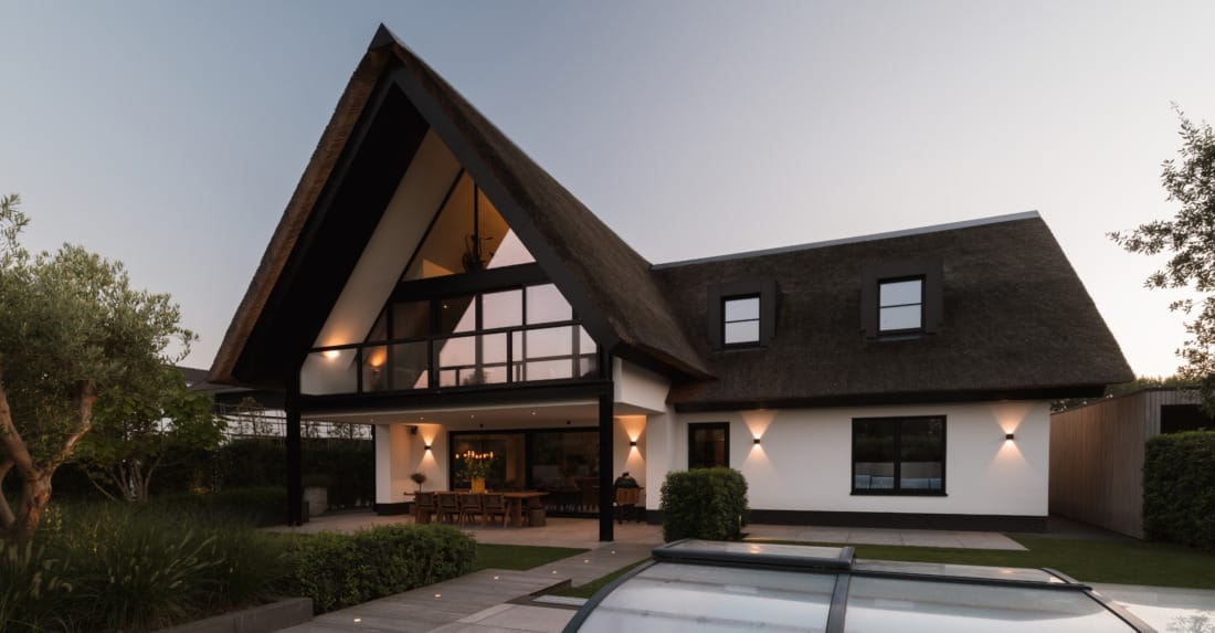 imposante entree van landhuis met klassieke buitenverlichting.