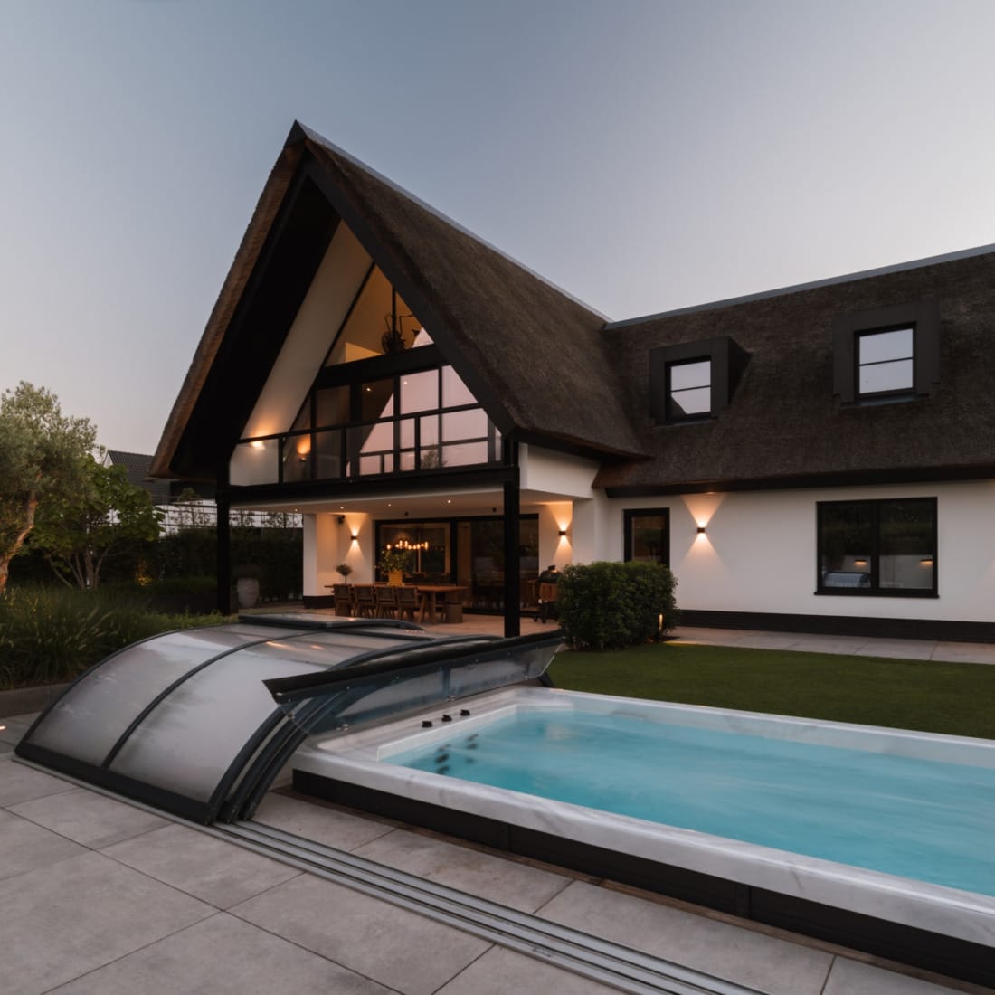 luxe bijgebouw met zwembad en sfeervolle avondverlichting.