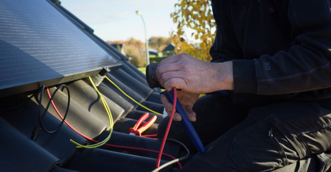 close-up aansluiten bekabeling zonnepanelen door domotiQa specialist.